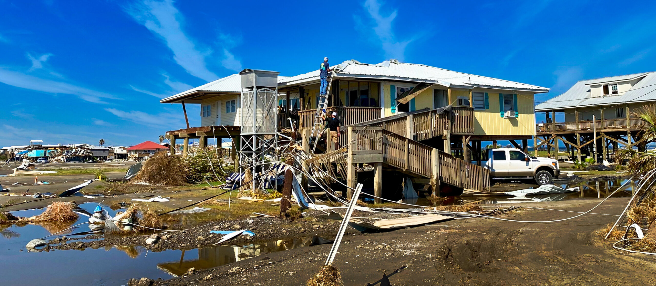 Grand Isle, LA Hurricane Ida Destruction, workers repairing camp or home on Isl