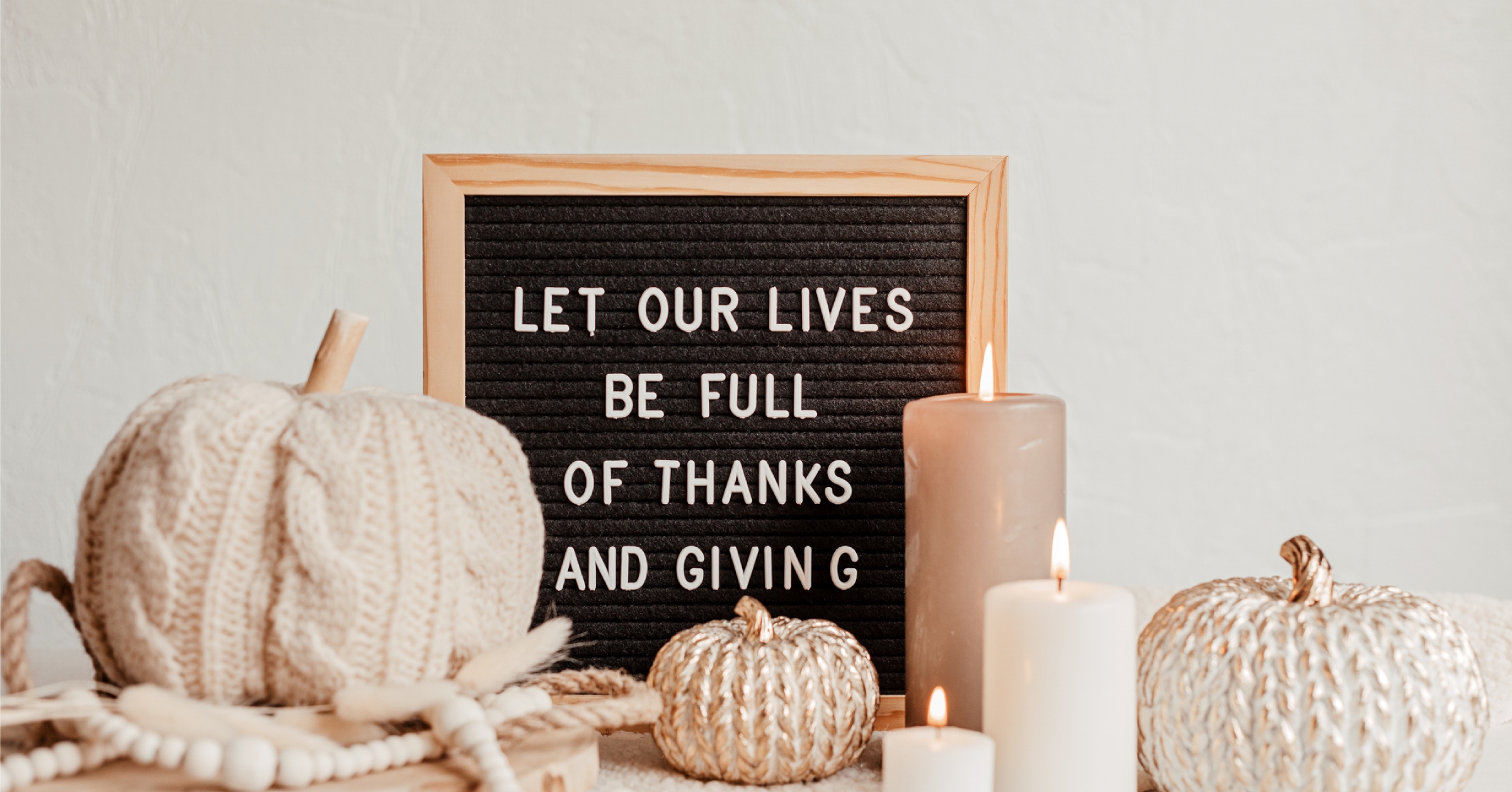 giving thanks thanksgiving fall season sign behind candles and pumpkin decorations
